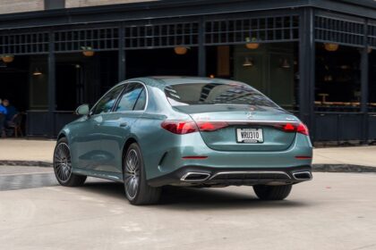 Rear three-quarter view of a teal Mercedes-Benz E450 sedan parked outdoors