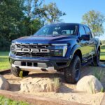 Blue Ford F-150 Raptor pickup truck on off-road display
