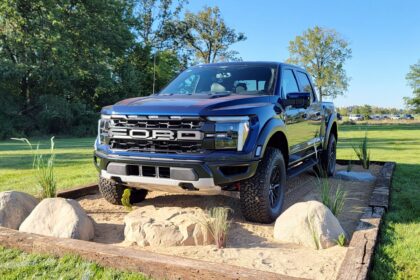 Blue Ford F-150 Raptor pickup truck on off-road display